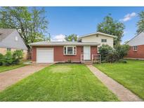 Charming brick home with a well-maintained lawn, attached garage and inviting curb appeal at 1330 Quari St, Aurora, CO 80011