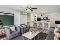 Inviting living room with a modern kitchen featuring a breakfast bar and sleek gray seating at 4899 S Dudley St # 15G, Littleton, CO 80123