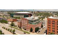 Stunning exterior view of a brick building with a modern glass rooftop addition, set against a vibrant cityscape backdrop at 1143 Auraria Pkwy # 203, Denver, CO 80204