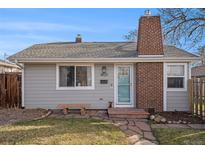 Charming ranch home with brick chimney and stone pathway at 4820 Newton St, Denver, CO 80221