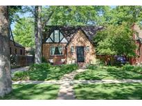 Charming brick home featuring a well-manicured lawn and mature trees for added curb appeal at 1661 Oneida St, Denver, CO 80220