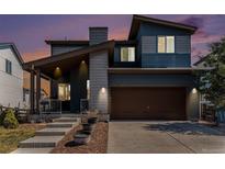 Charming two-story home featuring a covered front porch and a two-car garage at 10796 Truckee Cir, Commerce City, CO 80022