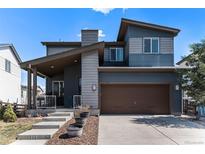 Charming two-story home featuring a covered front porch and a two-car garage at 10796 Truckee Cir, Commerce City, CO 80022