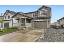 Charming two-story home with a covered porch, stone accents, and a two-car garage at 1420 E Witherspoon Dr, Elizabeth, CO 80107