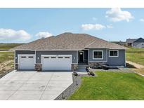Charming single-story home featuring a three-car garage and manicured lawn at 1180 Antelope W Dr, Bennett, CO 80102