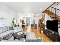 Bright and airy living room features modern decor, hardwood floors, and an open floor plan leading to the kitchen at 2706 Blake St, Denver, CO 80205