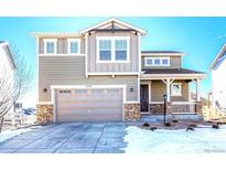 Two-story house with gray siding, stone accents, and a two-car garage at 27192 E Frost Pl, Aurora, CO 80016