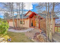 Inviting home featuring stone accents, a charming entryway, and a beautifully landscaped front yard at 2433 Dogie Spur, Golden, CO 80403