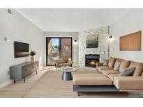 Bright living room with fireplace and sliding glass door to patio at 3526 S Depew St # 101, Lakewood, CO 80235