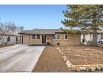 Charming single-story home featuring a covered entry, well-maintained lawn, and a detached garage at 1519 S Lowell Blvd, Denver, CO 80219