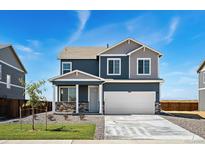 Charming two-story home with a two car garage, stone accents and a well manicured lawn at 2233 Base St, Fort Lupton, CO 80621