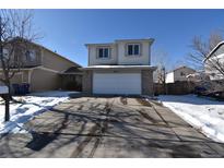 Two-story house with attached garage and snow-covered driveway at 6415 Raleigh St, Arvada, CO 80003