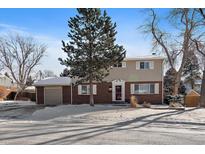 Two-story brick home with attached garage and snowy front yard at 6940 S Uinta St, Centennial, CO 80112