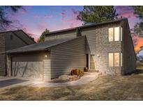 Inviting exterior showcasing a stone accent wall, two-car garage, and a well-maintained lawn at 1579 W Briarwood Ave, Littleton, CO 80120