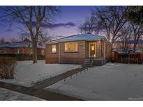 Brick ranch home with a landscaped yard, snowy lawn, and charming walkway at 3151 S Corona St, Englewood, CO 80113