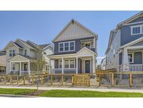 Charming two-story home with a covered front porch and a well-maintained lawn and decorative wood fence at 2702 E 103Rd Ave, Thornton, CO 80229