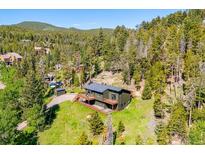 Stunning mountain home with a beautiful deck, surrounded by lush greenery and a scenic hillside at 34075 Grouse Ln, Evergreen, CO 80439