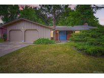 Charming home with a well-maintained lawn, two-car garage, and inviting blue front door at 2648 S Wadsworth Way, Lakewood, CO 80227