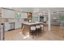 Modern kitchen features a large island, stainless steel appliances, and white and wood cabinetry at 41 Eagle Dr, Littleton, CO 80123