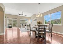 Bright dining area with hardwood floors, natural light and open floor plan to living area and outdoor patio at 19382 Dunraven St, Parker, CO 80134