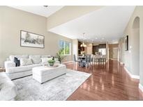 Bright open-concept living room and kitchen area with hardwood floors and neutral decor at 19382 Dunraven St, Parker, CO 80134