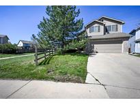 Two-story home features a two-car garage, fenced yard, and mature landscaping at 11191 W Crestline Dr, Littleton, CO 80127