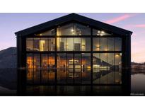 Modern home exterior with black trim and expansive windows reflected in the water at 6502 & 6200 Kiva Ridge Dr, Berthoud, CO 80513