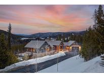 Beautiful mountain home with stone accents, a deck, and stunning views at dusk at 1279 Estates Dr, Breckenridge, CO 80424