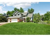 Charming two-story home with a well-manicured lawn and mature trees offering a peaceful curb appeal at 7999 Centrebridge Dr, Niwot, CO 80503