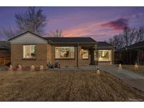 Charming brick home featuring well-maintained landscaping and a cozy front porch with exterior lights at 2960 Grape St, Denver, CO 80207
