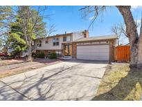 Charming two-story home with a brick facade, mature trees, and well-maintained landscaping at 7526 W Ottawa Pl, Littleton, CO 80128