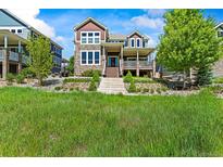 Beautiful two-story home with stone accents, a charming front porch, and well-maintained landscaping at 4378 Fell Mist Way, Castle Rock, CO 80109