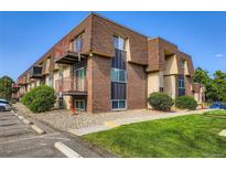 Charming building featuring brick and wood trim, complemented by well-maintained landscaping at 7755 E Quincy Ave # 104A6, Denver, CO 80237