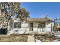 Ranch style home with a covered porch and small front yard at 1616 Oakland St, Aurora, CO 80010