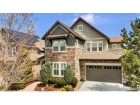 Charming two-story home featuring stone accents, an attached garage, and a well-manicured front yard at 10492 Willowwisp Way, Highlands Ranch, CO 80126