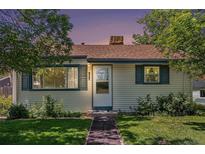 Charming single-story home featuring a well-maintained lawn, green shutters, and classic siding under a brown roof at 1979 Beeler St, Aurora, CO 80010