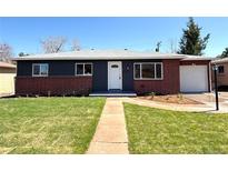 Charming single story home with a manicured lawn, inviting entryway, and beautiful exterior paint scheme at 2274 S Newton St, Denver, CO 80219