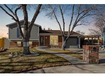 Brick ranch home with gray siding, landscaped yard, and attached garage at 16357 E Wyoming Dr, Aurora, CO 80017