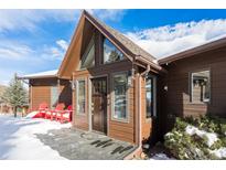 Inviting front entrance with a unique peak roof and a warm wood facade, showcasing a cozy and welcoming exterior at 610 Meadow View Dr, Evergreen, CO 80439