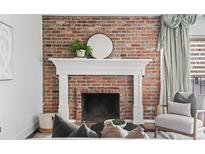 Living room featuring a brick fireplace with white mantle and round mirror at 700 N Washington St # 502, Denver, CO 80203