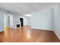 Bright living room features a fireplace and hardwood floors, offering a cozy and inviting atmosphere at 3550 S Harlan St # 174, Denver, CO 80235