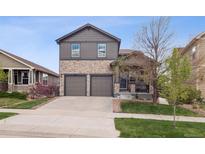 Charming two-story home featuring stone accents, a two-car garage, and a well-manicured front yard at 9084 Ellis Way, Arvada, CO 80005