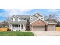Charming two-story home featuring a brick facade and a well-manicured lawn, with solar panels on the roof at 5962 S Sheridan Way, Littleton, CO 80123