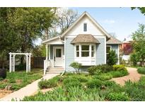 Charming home with light blue siding, well-manicured landscaping, and a welcoming front porch at 539 Baker St, Longmont, CO 80501