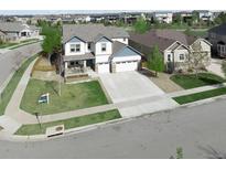 Beautiful two-story home with a well-maintained lawn and a spacious three-car garage at 404 Dusk Ct, Erie, CO 80516