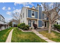 Charming townhome with blue and cream siding, complemented by a well-manicured lawn and walkway at 1612 S Idalia Cir # A, Aurora, CO 80017