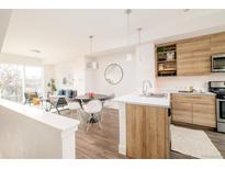 Open concept kitchen and dining area with modern cabinetry and island at 5653 W 10Th Ave, Lakewood, CO 80214