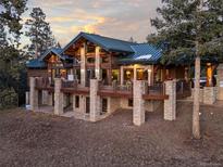 Stunning timber frame home with stone accents and a wrap-around deck, offering exceptional views and outdoor living at 4446 Songbird Ln, Evergreen, CO 80439