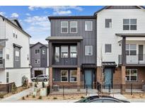 Charming two-story townhome with brick accents, a fenced yard, and a private balcony on the second floor at 6834 Merseyside Ln, Castle Pines, CO 80108