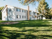 Attractive condo building with stone accents, balconies, and manicured lawn at 14413 E Jewell Ave # 201, Aurora, CO 80012